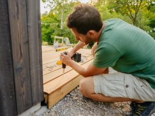 Contractor working on Trex deck board spacing for a new patio installation.